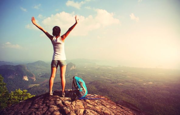 woman hiker enjoy the view on mountain peak cliff